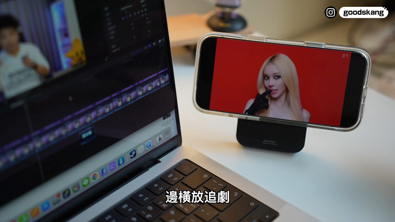 手機吸在行動電源的支架上,橫放在筆電旁追劇